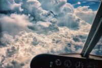 Aircraft instrument panel overlooking towering clouds from the cockpit